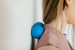 Zwei blaue Massagebälle, die zur Selbstmassage an der Wand verwendet werden, um Verspannungen im Nacken- und Schulterbereich zu lösen. Effektive Ergänzung zur CMD-Physiotherapie.