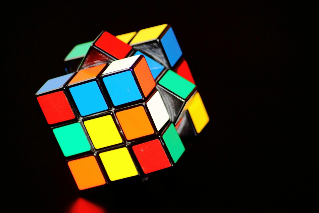 Ein bunter Rubik's Cube vor schwarzem Hintergrund – symbolisiert die Komplexität der kognitiven Prozesse und die Rolle der CBT bei der Bewältigung von CMD.