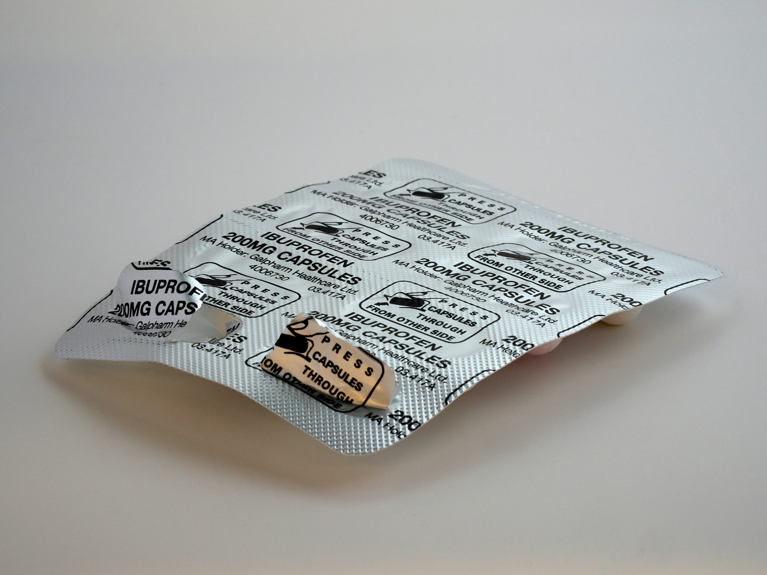 Eine geöffnete Blisterpackung mit Ibuprofen-Tabletten auf einem hellen Hintergrund. Dieses Bild veranschaulicht den Einsatz von NSAR wie Ibuprofen zur entzündungshemmenden und schmerzlindernden Behandlung von CMD.